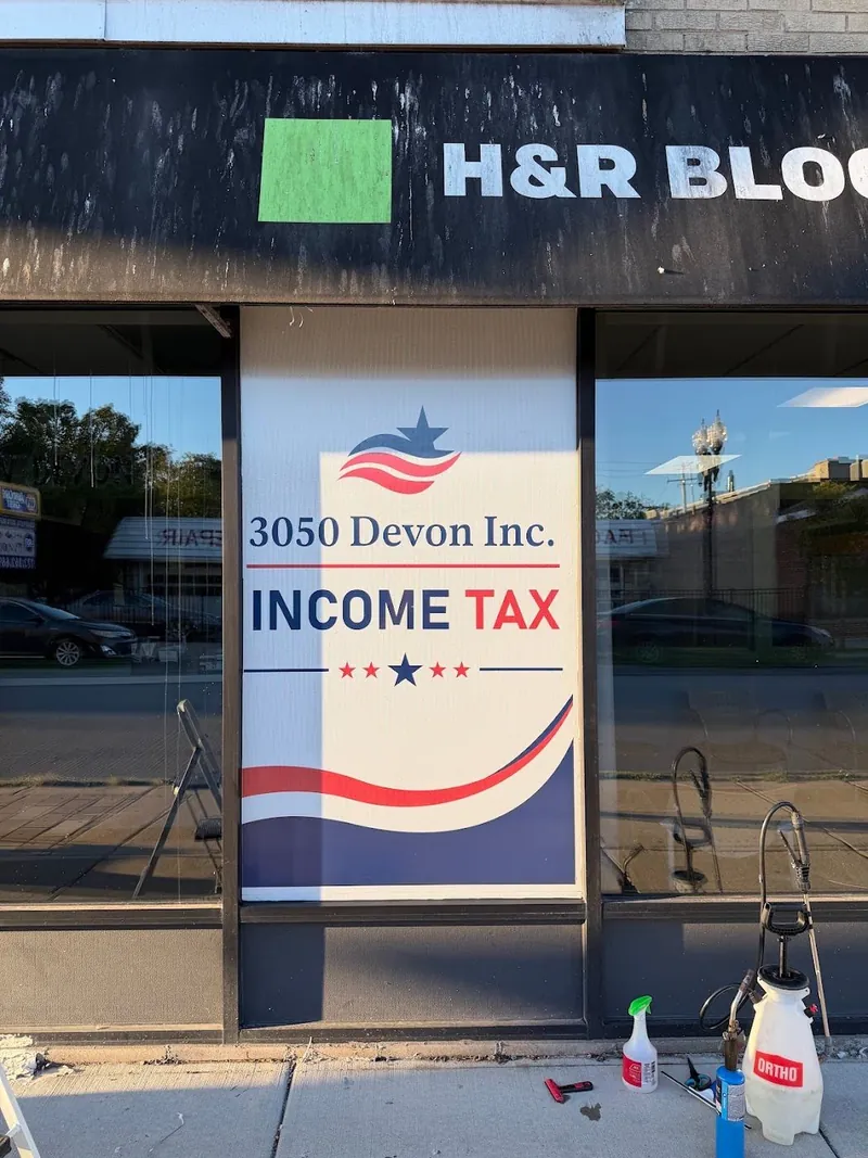 Storefront window with a large red, white and blue Income Tax graphic for 3050 Devon Inc.