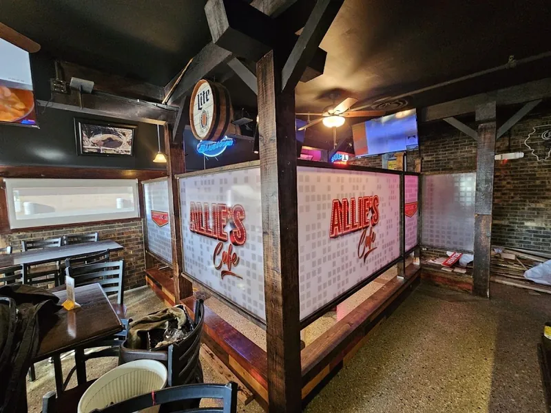 Restaurant booths separated by wood-framed panels printed with the Allie's Café logo