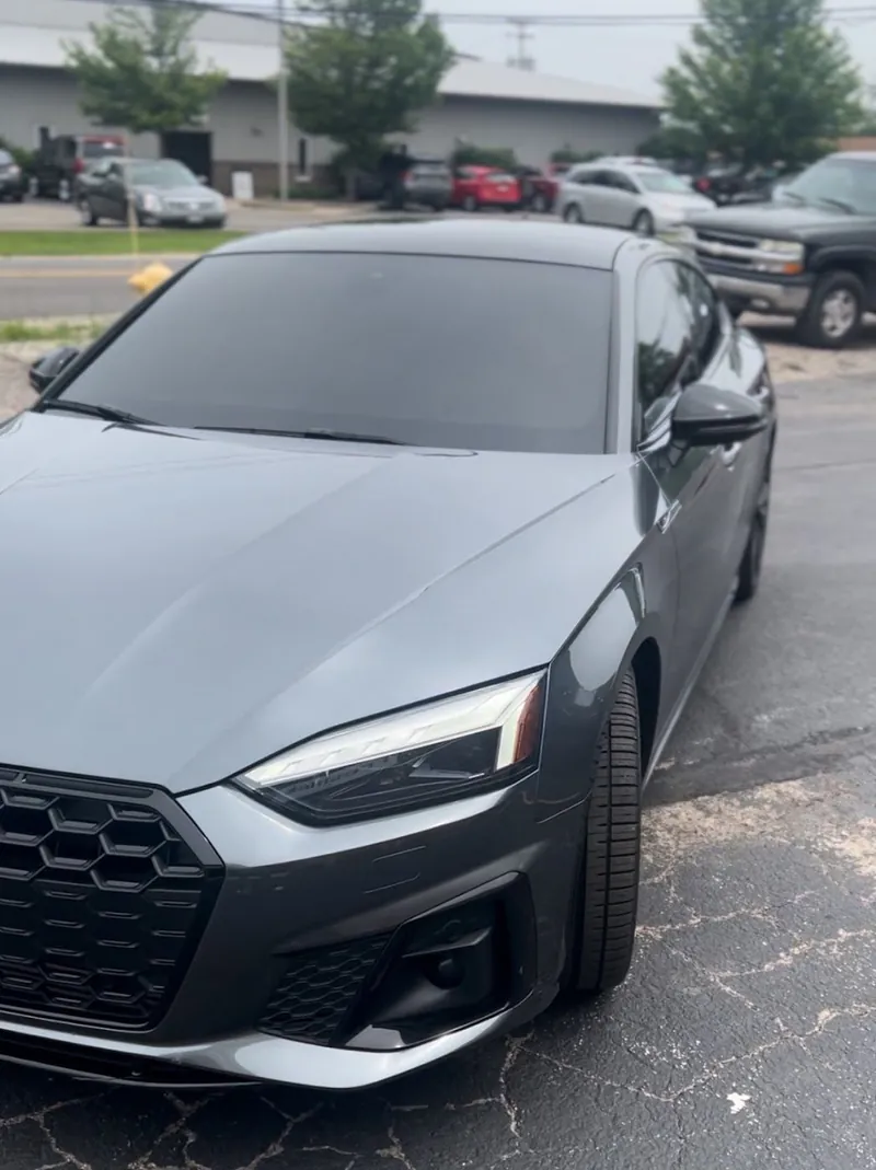 Gray Audi sedan with dark tinted windows parked in a lot