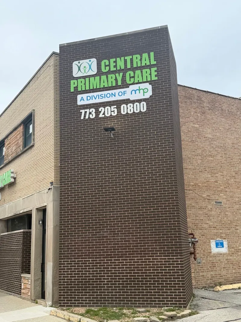 Tall brick building corner with a Central Primary Care sign and phone number