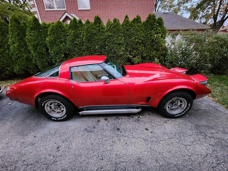 Side view of a classic Corvette in a glossy candy red wrap