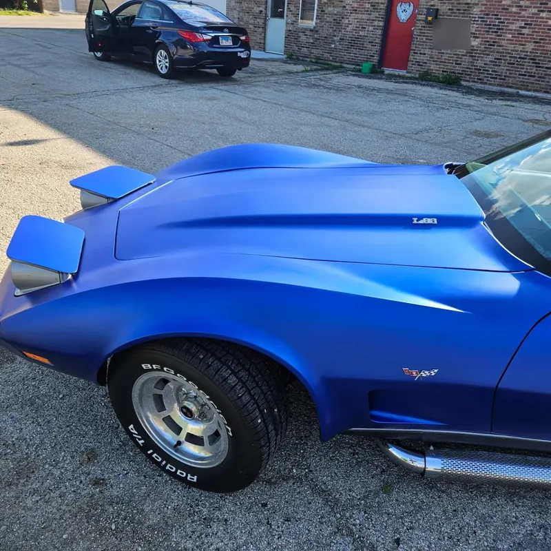Classic Corvette wrapped in matte chrome blue, seen from the front quarter
