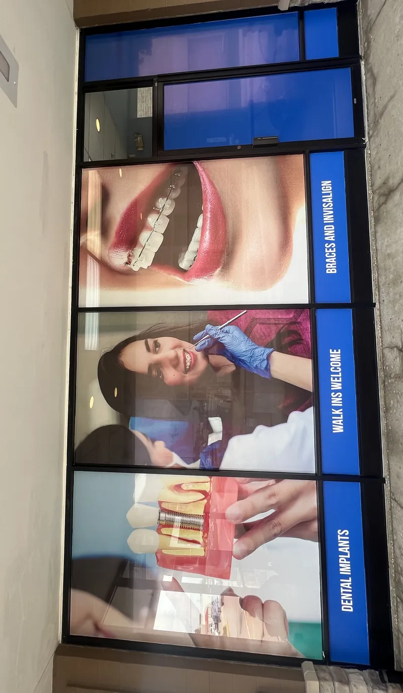Close-up of printed window panels advertising braces and Invisalign, dental implants and walk-ins welcome