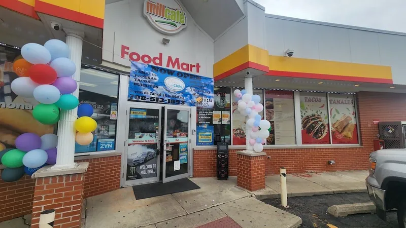 Food Mart entrance with printed window graphics and grand-opening balloon columns
