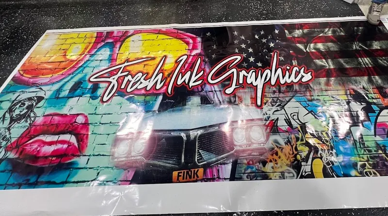Large graffiti-style print with Fresh Ink Graphics script lettering laid out beside the printer