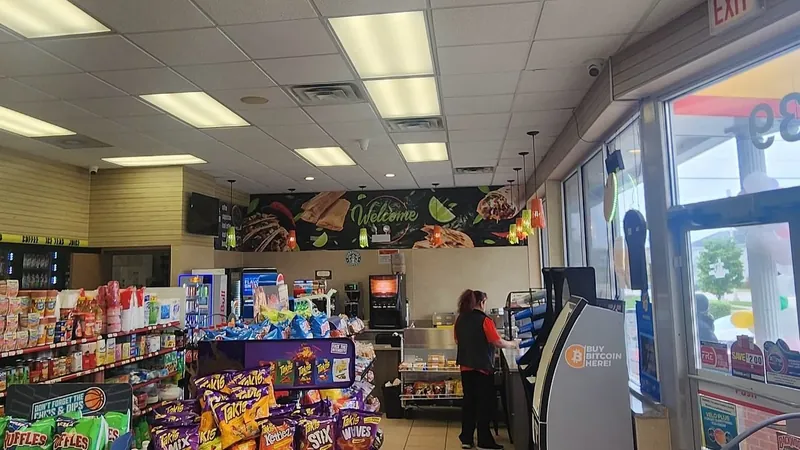 Food-themed welcome wall graphics above the counter inside a gas station convenience store