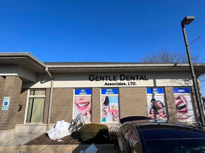 Gentle Dental Associates building with oral surgery, implants, root canals and braces window graphics under a clear blue sky