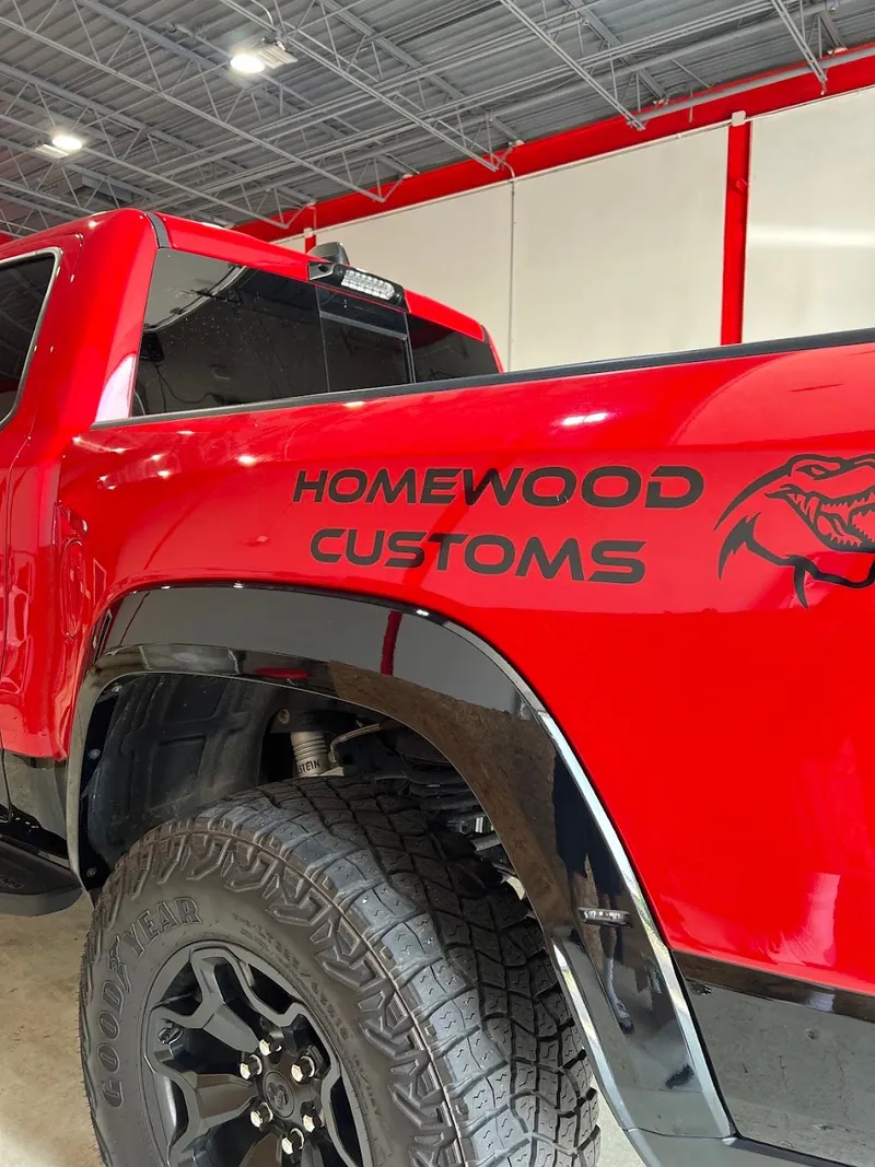 Red pickup with black Homewood Customs lettering and logo on the rear door