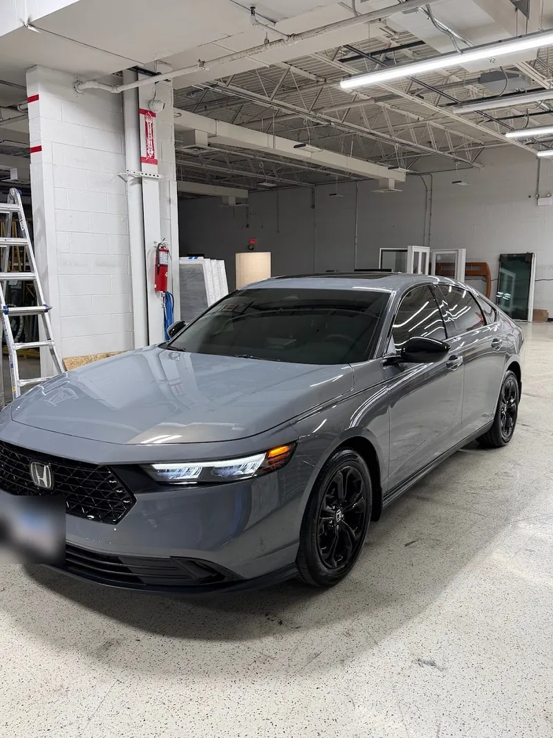 Gray Honda Accord with tinted windows inside the shop