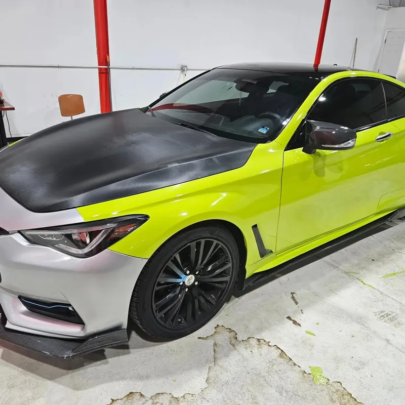 Front quarter of an Infiniti Q60 wrapped in lime green with a black carbon-look hood