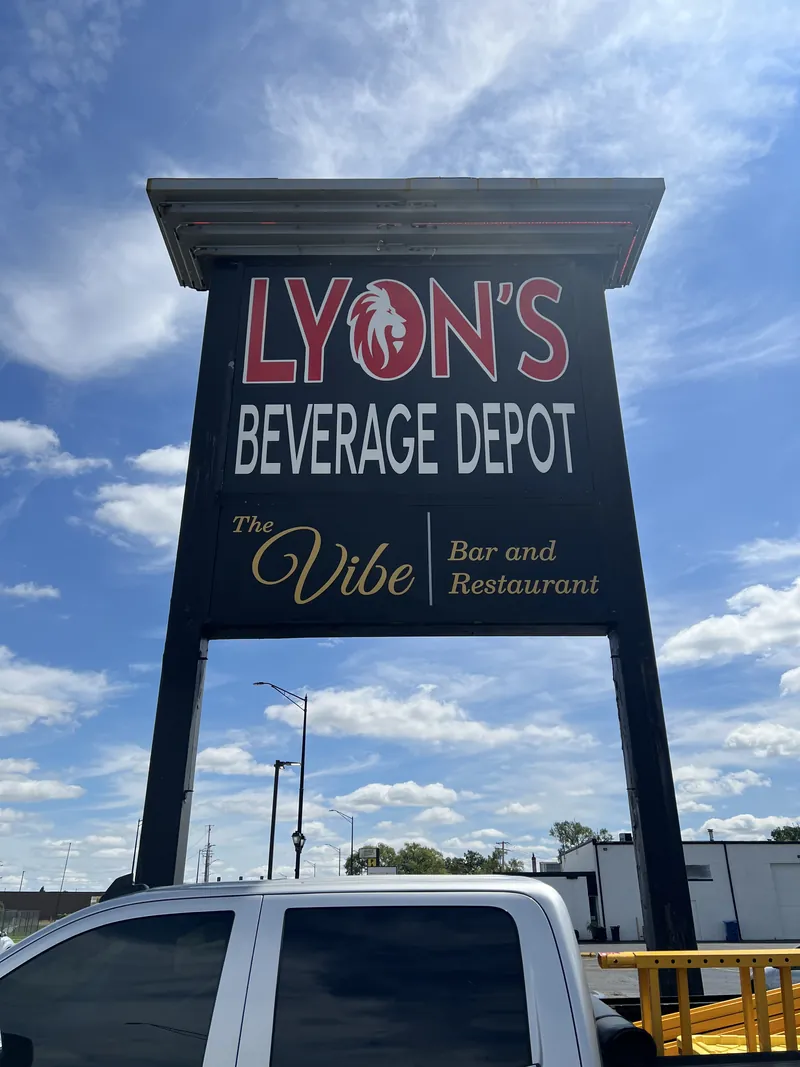 Tall pylon sign with Lyon's Beverage Depot and The Vibe Bar and Restaurant panels against a blue sky