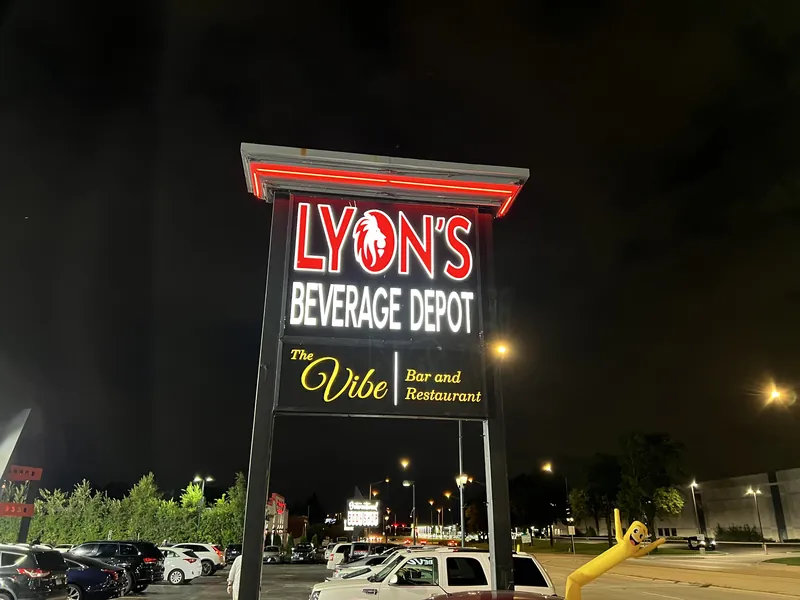 Illuminated Lyon's Beverage Depot pylon sign glowing at night above a parking lot