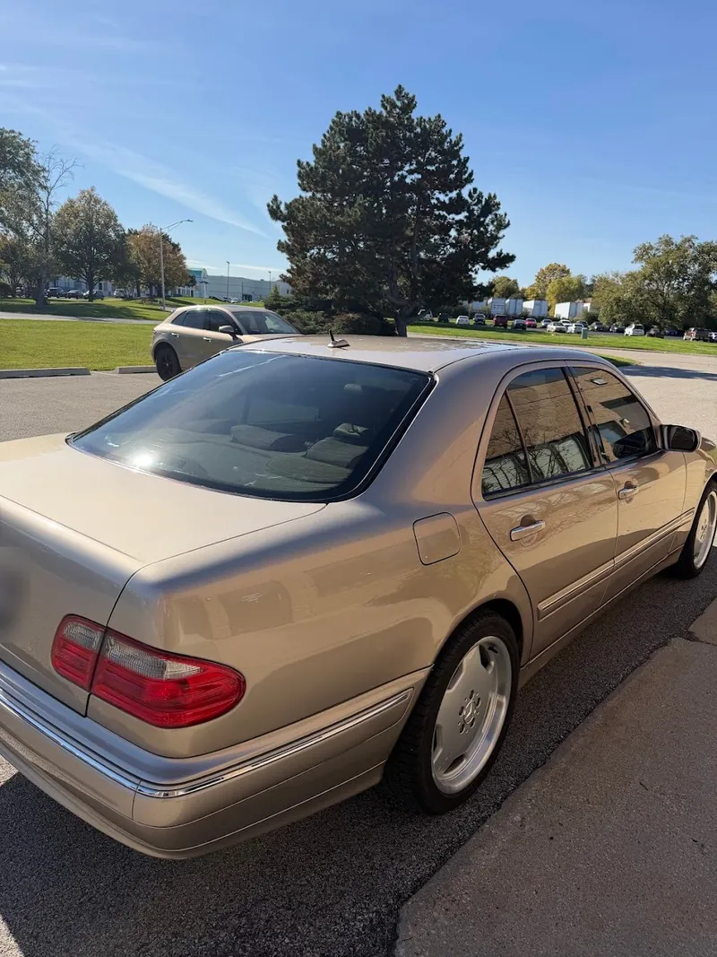 Champagne Mercedes-Benz sedan with freshly tinted rear and side windows, parked outside
