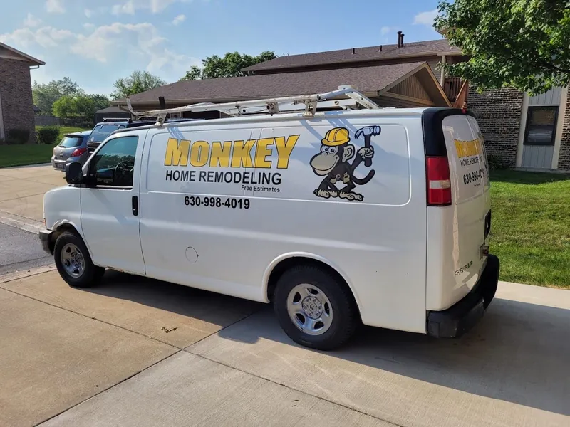 White cargo van with yellow Monkey Home Remodeling lettering, a cartoon monkey mascot and phone number