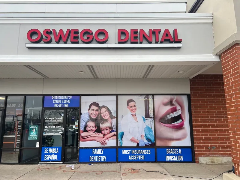 Oswego Dental storefront with family and patient photos and blue service headers covering the windows