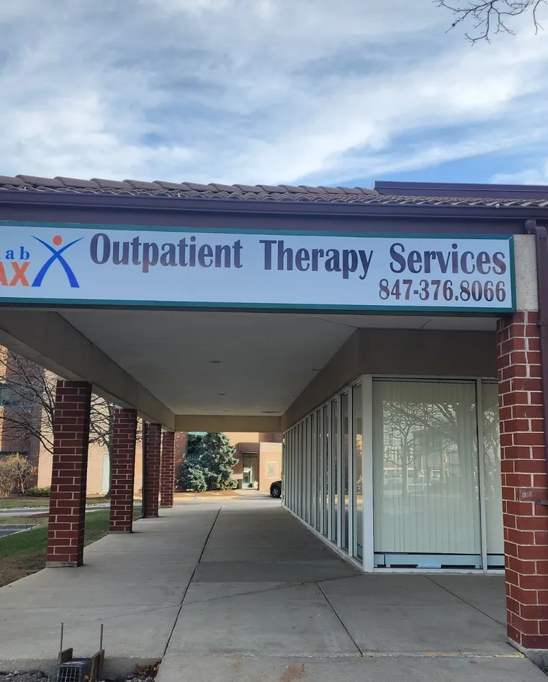 Rehab Max Outpatient Therapy Services sign with phone number above a covered walkway