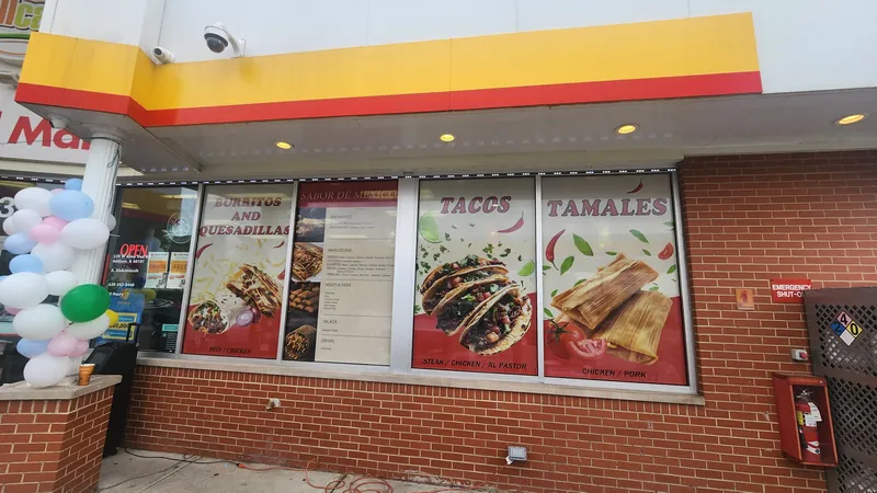Restaurant windows with printed food graphics for tacos and tamales and a menu panel