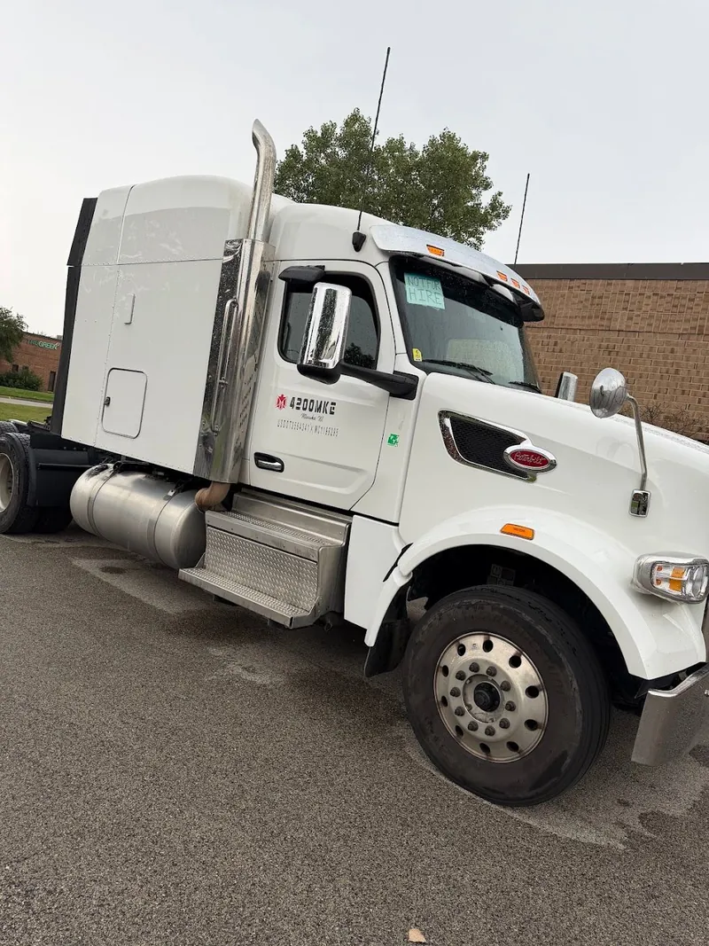 White semi-truck tractor with company lettering on the cab door