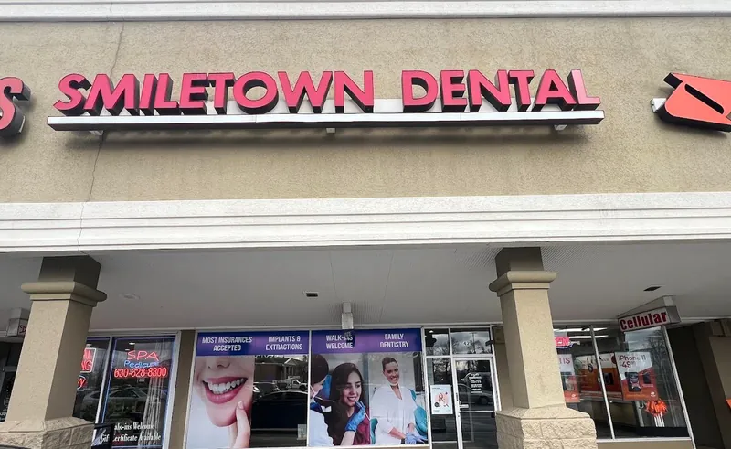 Smiletown Dental storefront with purple service headers and patient photos across the windows