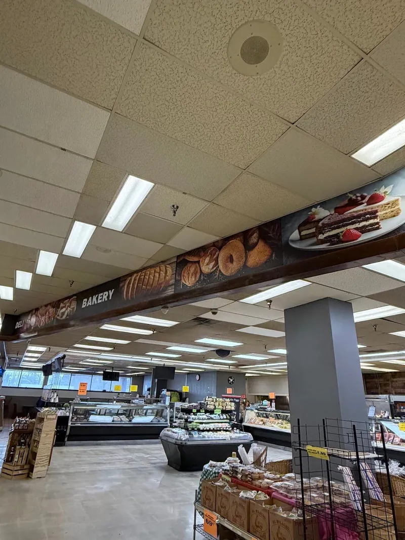 Long printed banner of breads and pastries above the bakery section of a supermarket