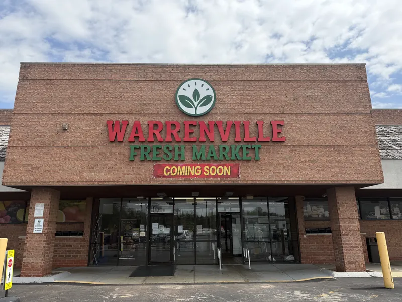 Warrenville Fresh Market storefront with a red and green building sign, leaf logo and a Coming Soon banner